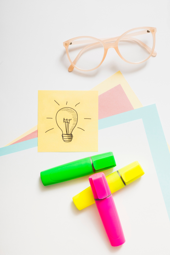 Post it note with lightbulb and highlighter pens