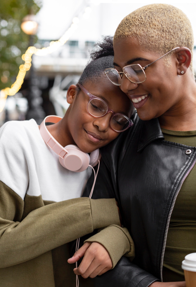 Teen girl and mother embracing and smiling.