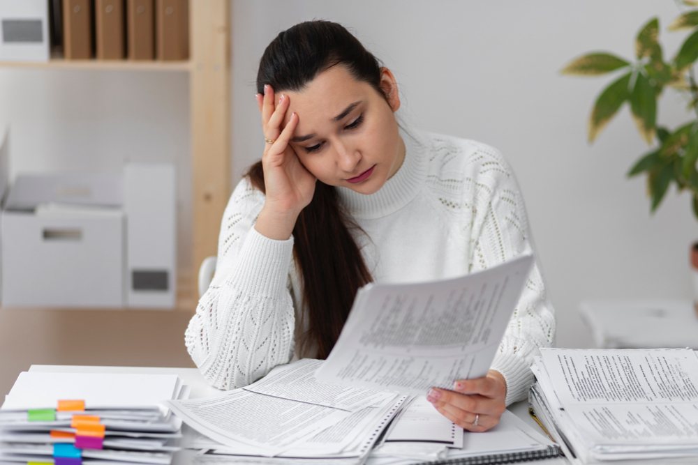 Stressed woman reading paperwork