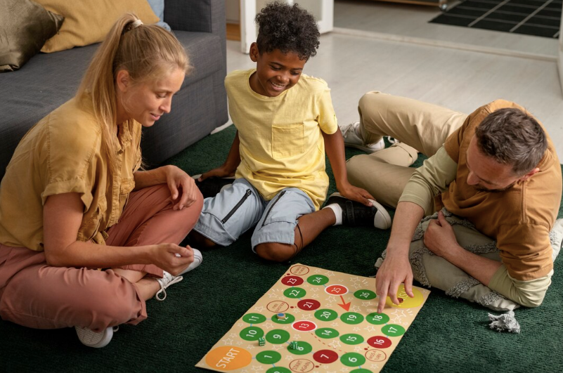 boy playing a board game with his parents