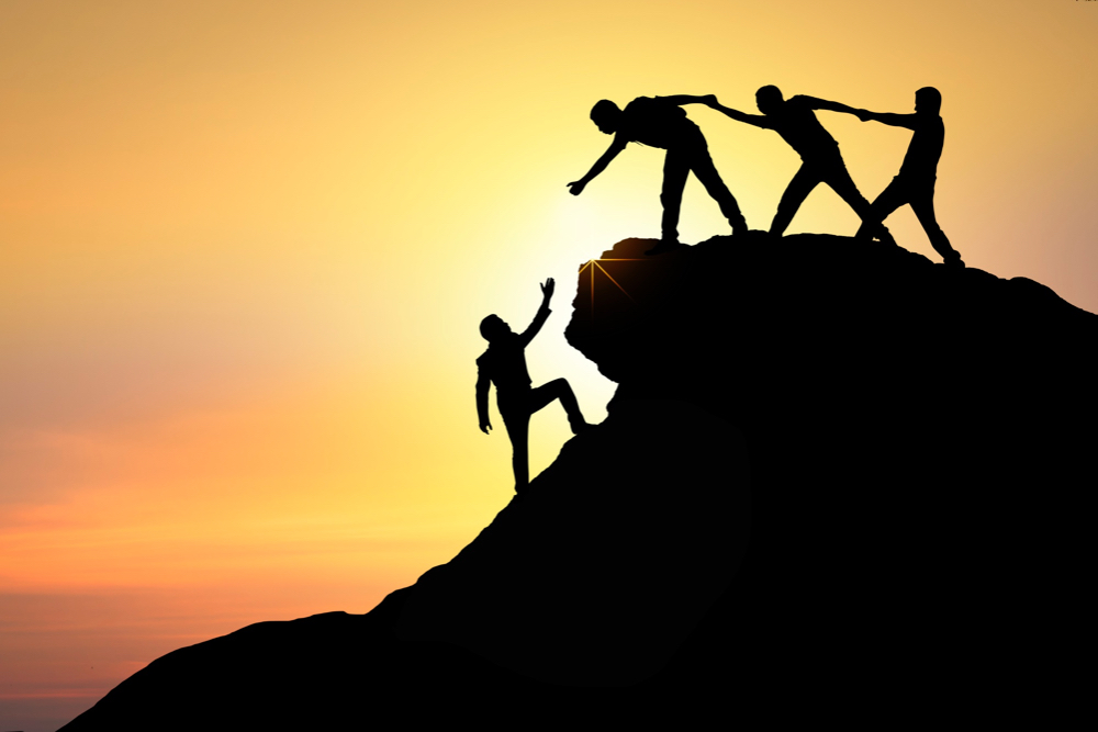 climbing a mountain with teamwork