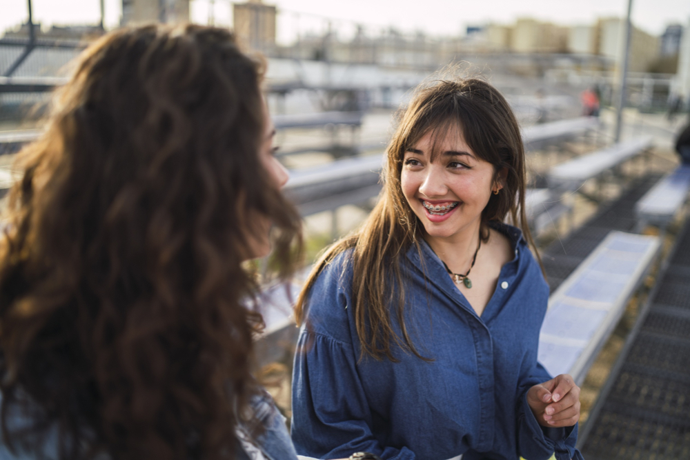girl with braces smiling laughing talking to mentor